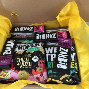 Treat Trunk Halloween vegan snack box, open and packed with Zombie fruit bars, Proper Chips and yellow tissue paper