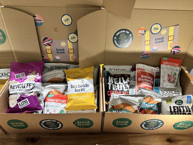 Two open Full Treat Trunk office snack boxes packed with full-size healthy snacks from small UK makers